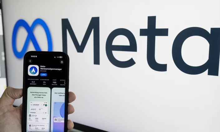 Inhalte, die deine Community erreichen Hand hält ein Smartphone mit dem Meta-Werbeanzeigenmanager vor dem Meta-Logo