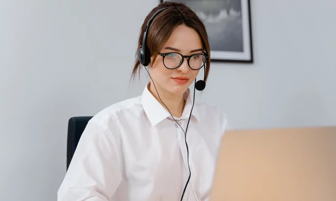 Kundenberaterin mit Headset am Laptop im Büro