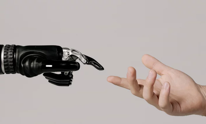 KI als Unterstützung im Tagesgeschäft bei der Content-Erstellung Bild einer Roboterhand und einer menschlichen Hand, die sich fast berühren